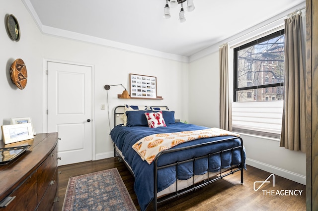 bedroom with baseboards, dark wood-style floors, and crown molding