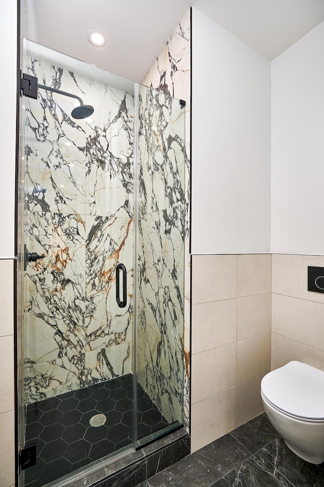 bathroom featuring a marble finish shower, toilet, recessed lighting, marble finish floor, and tile walls