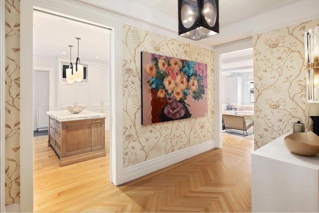 hallway with wallpapered walls, parquet flooring, baseboards, and ornamental molding