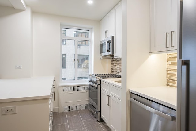 kitchen featuring appliances with stainless steel finishes, white cabinets, light countertops, tasteful backsplash, and recessed lighting