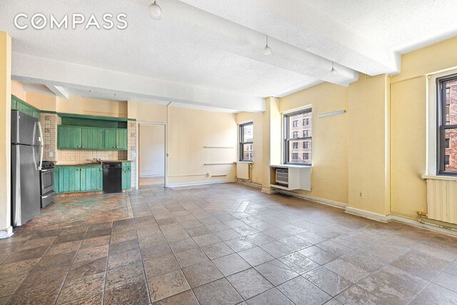 unfurnished living room featuring cooling unit, radiator, and a textured ceiling