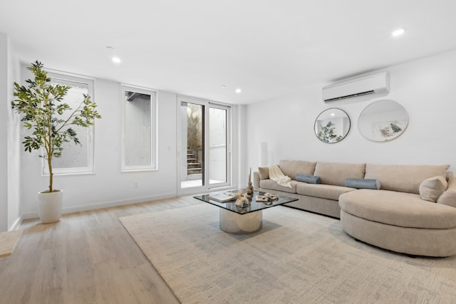 living room featuring a wall mounted AC and light hardwood / wood-style flooring