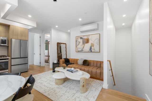 living room with light wood-type flooring and a wall unit AC