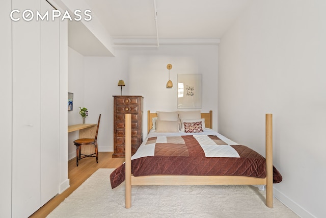 bedroom with baseboards and wood finished floors