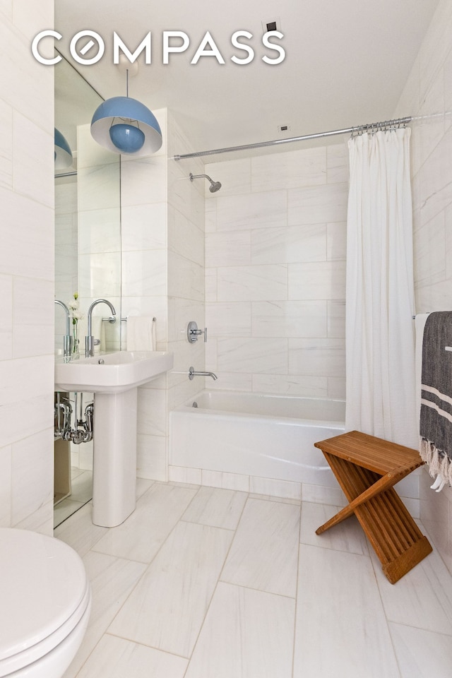 full bathroom featuring tile walls, toilet, and shower / tub combo with curtain