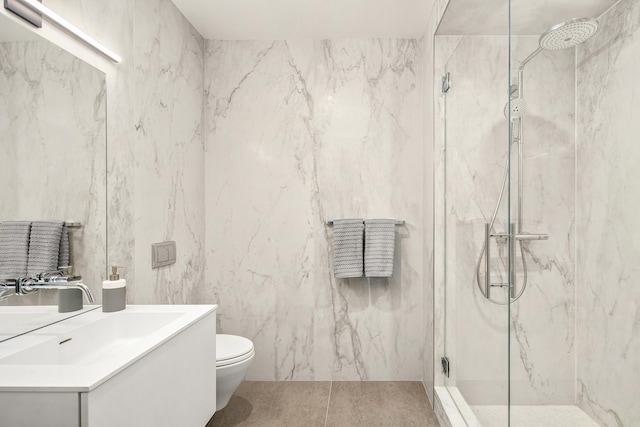 bathroom featuring toilet, a marble finish shower, and vanity