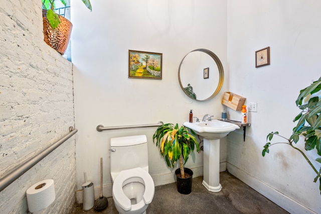 bathroom featuring sink, concrete floors, and toilet