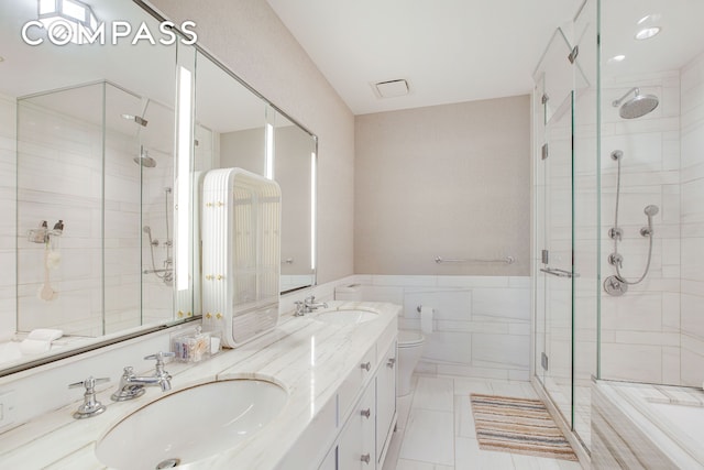 bathroom with a sink, tile walls, and a shower stall