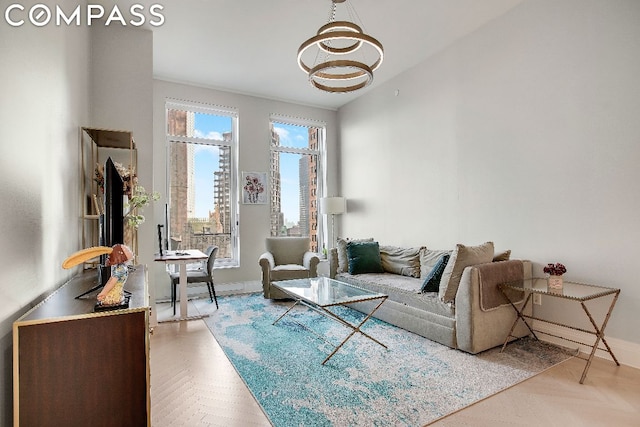 living room with an inviting chandelier, plenty of natural light, and light parquet flooring