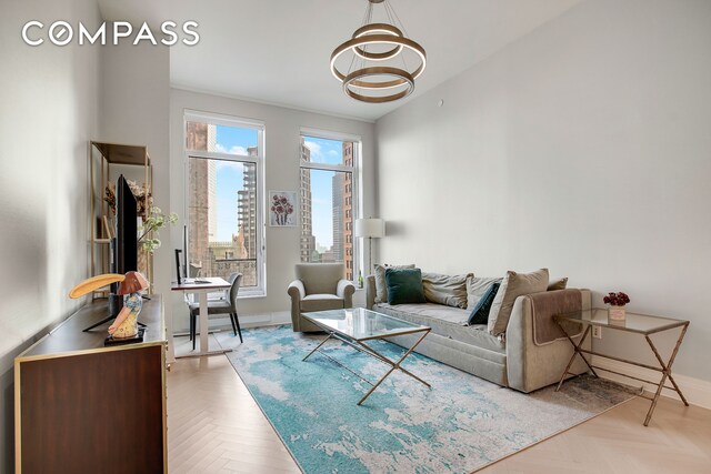 living room with light parquet floors and a chandelier