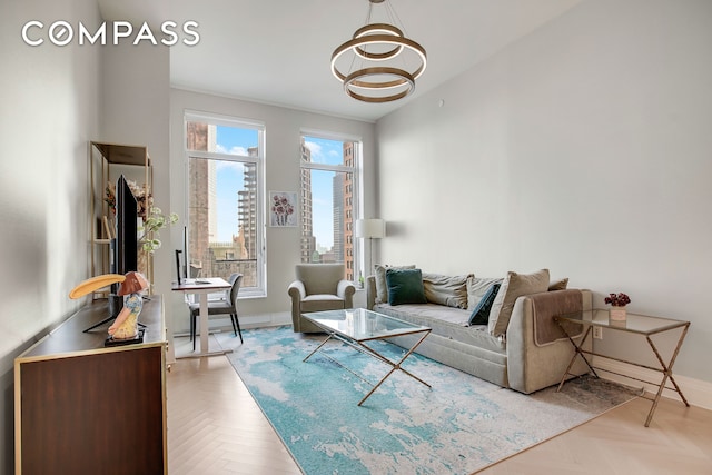 living room featuring a notable chandelier and baseboards