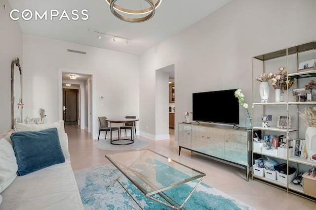 living area featuring visible vents, baseboards, and wood finished floors