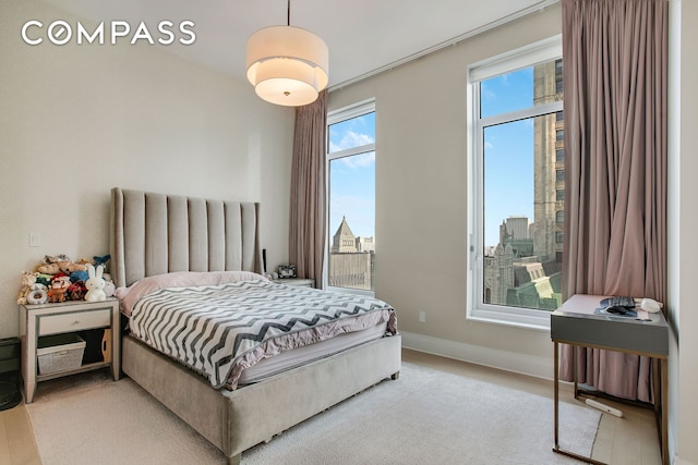 bedroom with light wood finished floors and baseboards