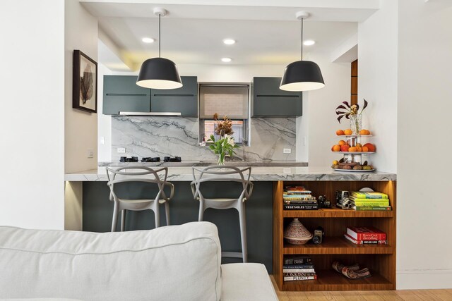 kitchen with decorative backsplash, a breakfast bar area, and hanging light fixtures