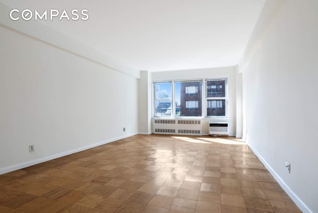 interior space featuring radiator, baseboards, and a wall mounted AC