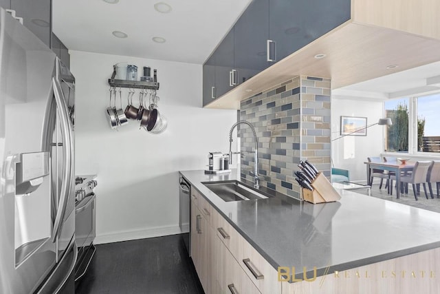 kitchen with appliances with stainless steel finishes, sink, and decorative backsplash