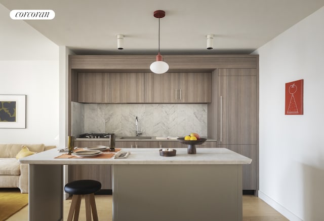 kitchen featuring visible vents, modern cabinets, a center island, pendant lighting, and a sink