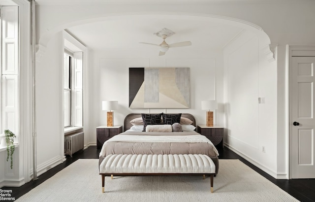 bedroom featuring dark wood-type flooring, ceiling fan, and radiator