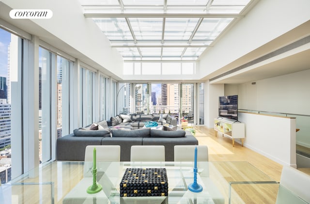 living area with visible vents, a wall of windows, and wood finished floors