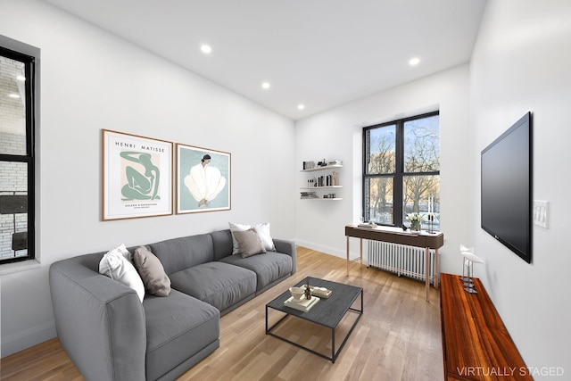 living area featuring recessed lighting, radiator, baseboards, and wood finished floors