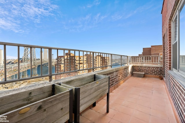 balcony with a water view and a view of city