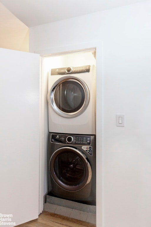 washroom featuring stacked washer and dryer and light hardwood / wood-style floors