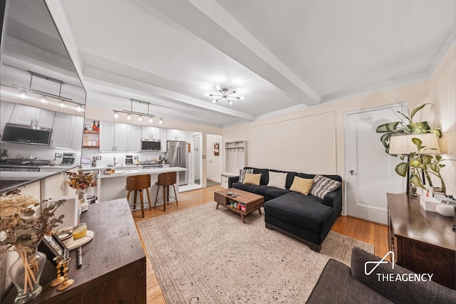 living room with light wood-style floors and beamed ceiling