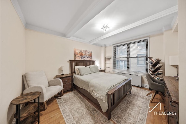 bedroom featuring radiator heating unit, ornamental molding, beamed ceiling, and light wood-type flooring