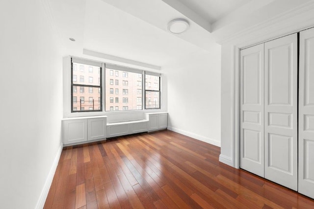 unfurnished bedroom with dark hardwood / wood-style flooring and a closet