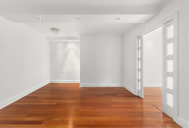 empty room featuring crown molding and wood-type flooring