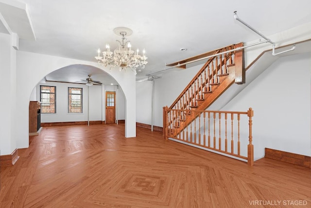 interior space with ceiling fan with notable chandelier and parquet flooring