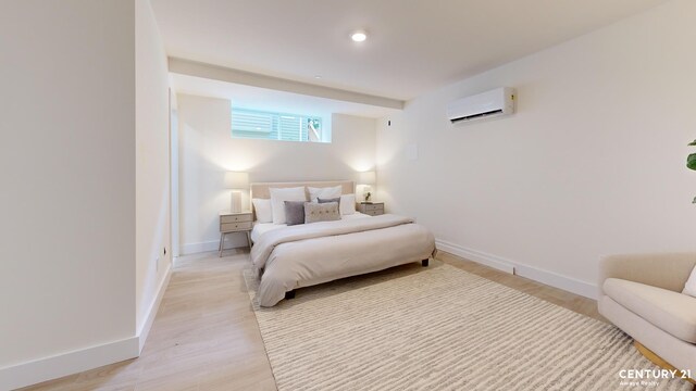 bedroom with a baseboard heating unit and light wood-type flooring