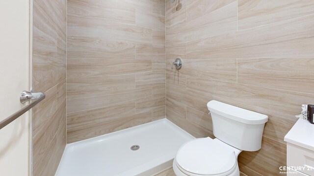 full bathroom with shower / tub combo with curtain, vanity, toilet, and tile walls