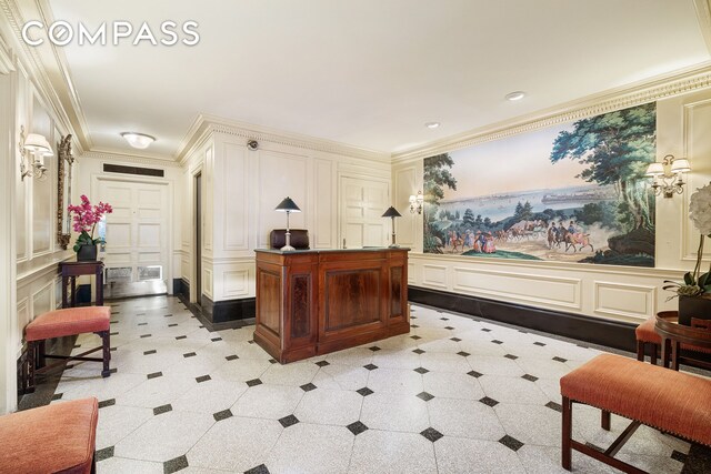 corridor with crown molding, hardwood / wood-style flooring, and an inviting chandelier