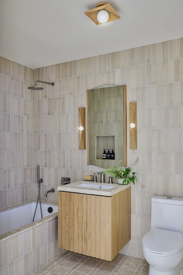 323 Bergen St Unit 119E, New York City, NY 11217 - bathroom with tile walls, vanity, tile patterned floors, and tiled shower / bath