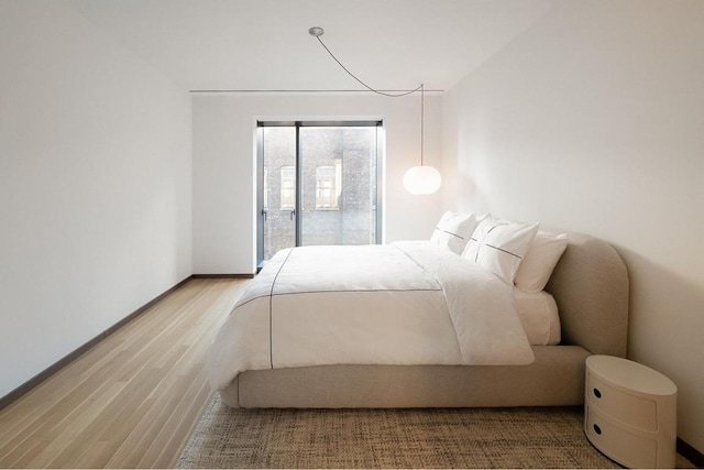 bedroom featuring wood-type flooring and access to outside