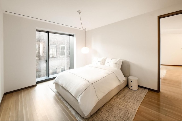 bedroom featuring access to exterior and hardwood / wood-style floors