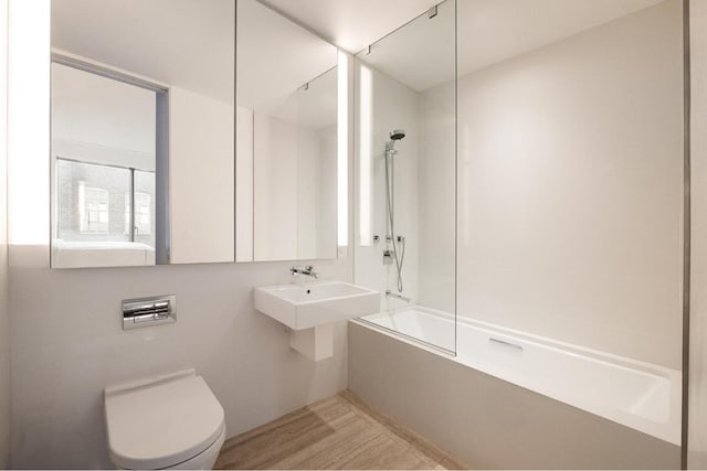 full bathroom featuring hardwood / wood-style flooring, shower / bathing tub combination, sink, and toilet