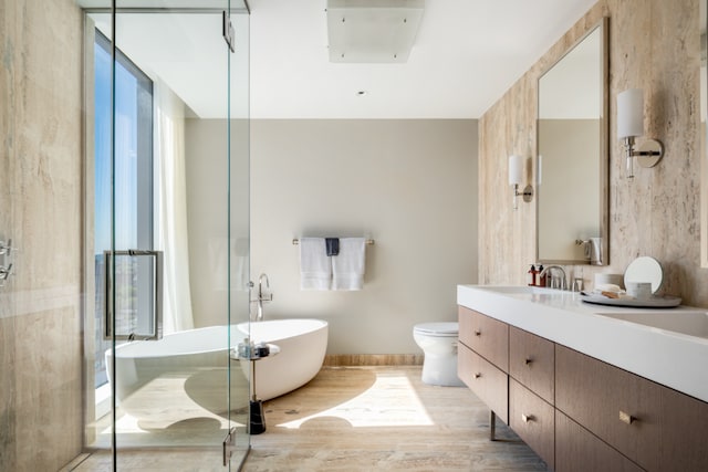 full bathroom with vanity, wood-type flooring, independent shower and bath, and toilet