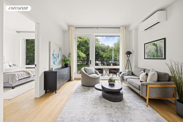 living room featuring a wall mounted air conditioner, visible vents, plenty of natural light, and light wood-style floors