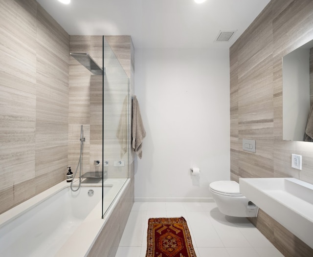 bathroom with tile walls, visible vents, toilet, tile patterned flooring, and baseboards