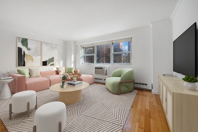 living room featuring a baseboard radiator, a wall mounted air conditioner, ornamental molding, and light wood-type flooring