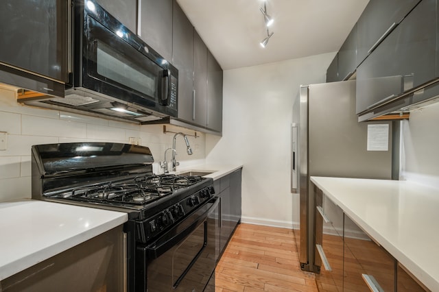 122 Ashland Pl Unit 3D, New York City, NY 11201 - kitchen with black appliances, light wood-style floors, a sink, decorative backsplash, and light countertops