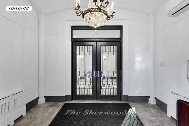 entryway with vaulted ceiling, french doors, a wall mounted AC, and a decorative wall