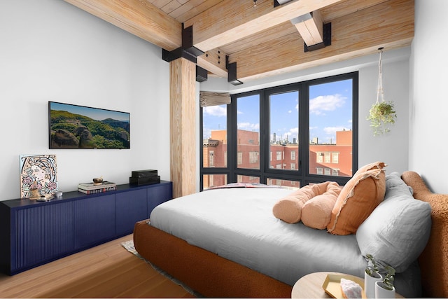 bedroom featuring wooden ceiling, light wood-style floors, and beamed ceiling