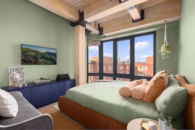 bedroom featuring beamed ceiling, hardwood / wood-style floors, and wooden ceiling