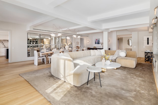 living area featuring beam ceiling and wood finished floors