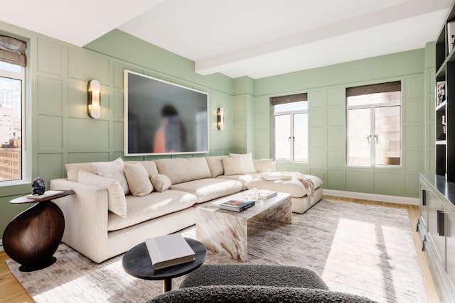 living room with beam ceiling and light hardwood / wood-style flooring