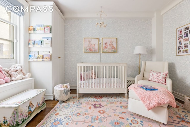 bedroom featuring a nursery area and hardwood / wood-style floors