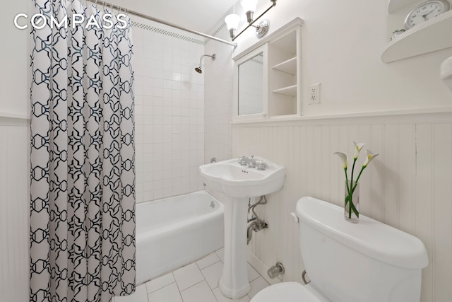 345 E 52nd St Unit 8G, New York City, NY 10022 - full bathroom featuring shower / bathtub combination with curtain, wainscoting, and tile patterned flooring